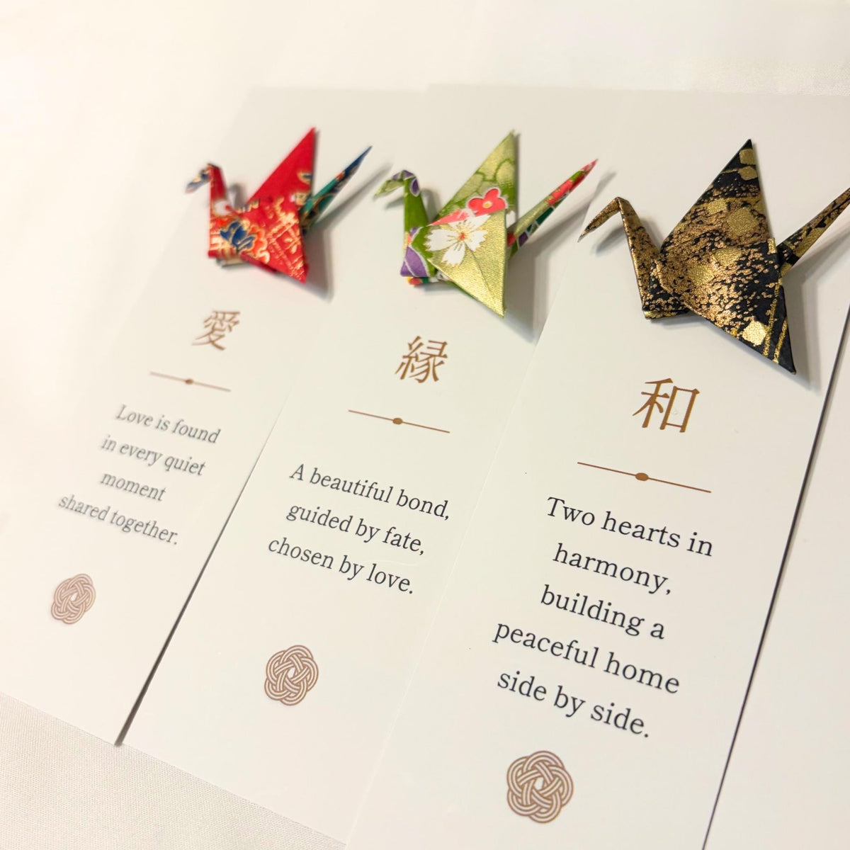 Kanji blessing bookmarks laid out with origami cranes in Japanese washi paper