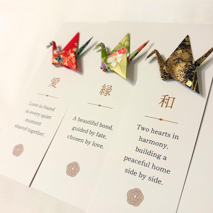 Kanji blessing bookmarks laid out with origami cranes in Japanese washi paper