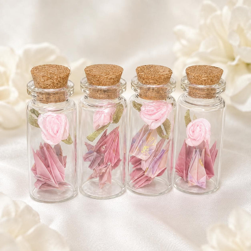 Mini origami cranes and a ribbon rose in a corked glass bottle