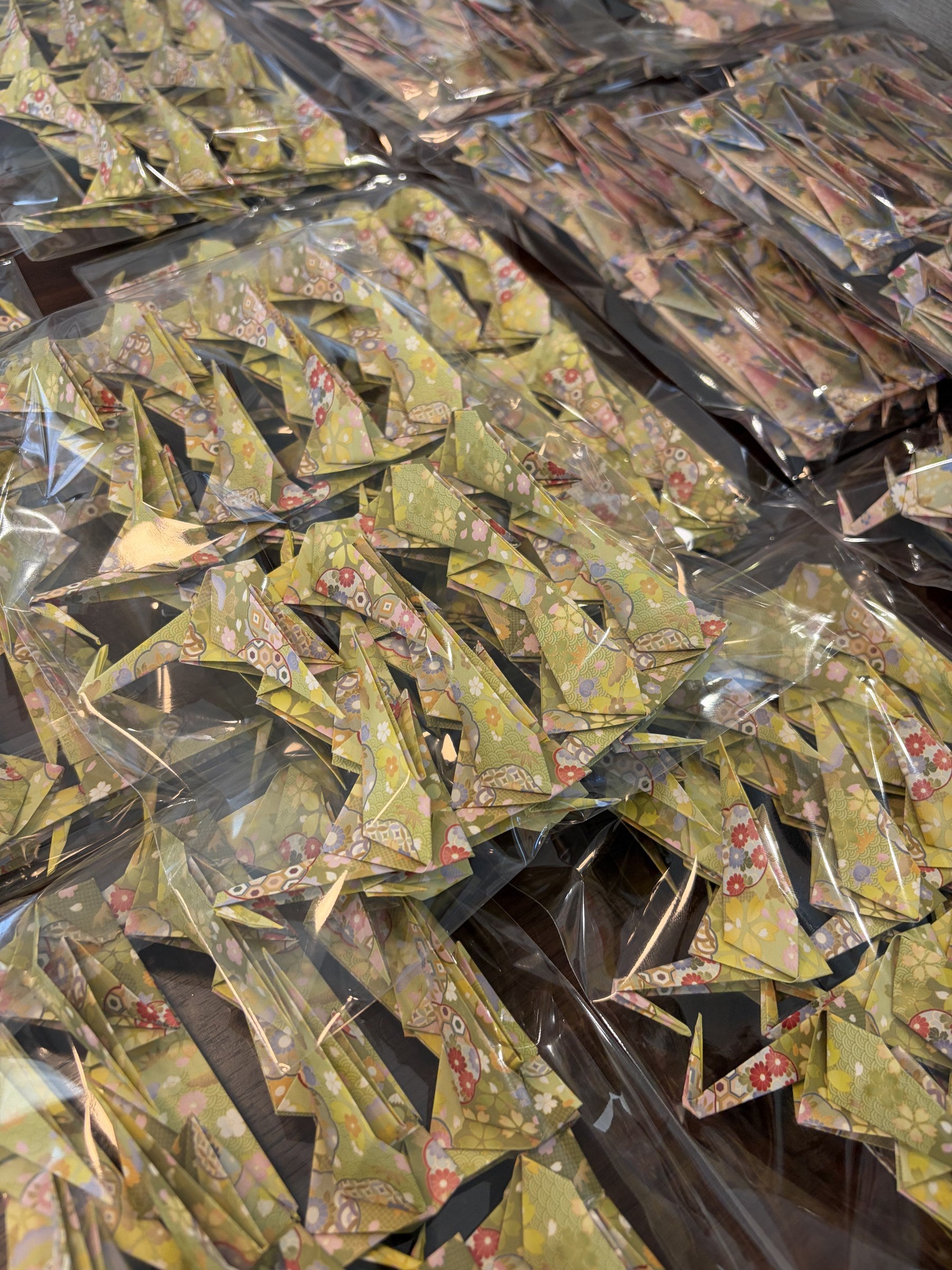 Origami cranes grouped in clear protective bags before packing, in the MATOI studio